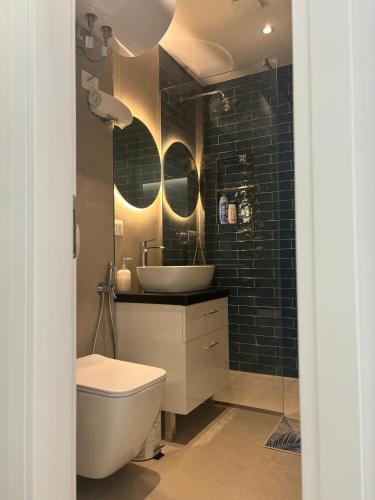 a bathroom with a sink and a toilet and a mirror at Apartments Keesi 1 in Durrës