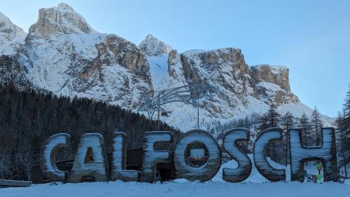 a sign in the snow in front of a mountain at Garni Diamant in Colfosco