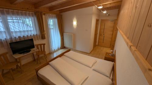 a small room with a bed and a television at Garni Diamant in Colfosco