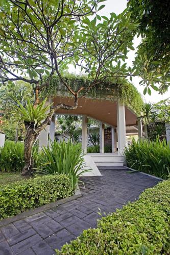 a building with a tree in front of it at Dewi Sri Hotel in Legian