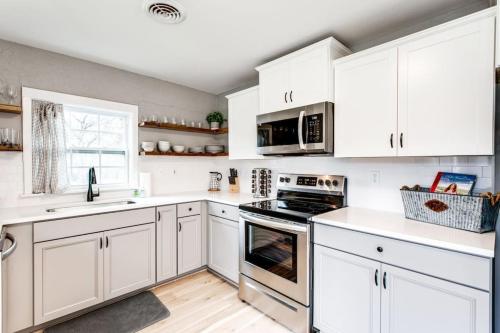a kitchen with white cabinets and a stove top oven at Brookwood Getaway Stock Tank Pool Outdoor Theater in Franklin