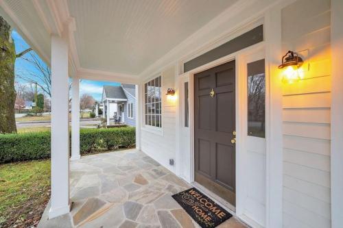 a home with a black door and a porch at Brookwood Getaway Stock Tank Pool Outdoor Theater in Franklin