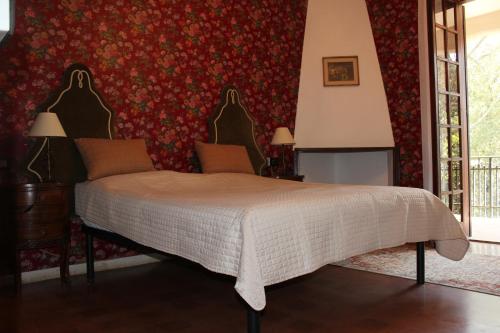 a bedroom with a bed and a red wall at Villa Orio Lake Piediluco in Piediluco