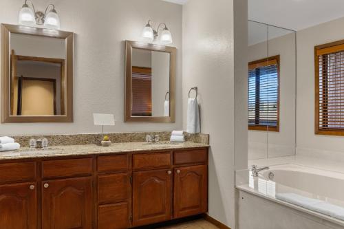 a bathroom with two sinks and a bath tub and a tubermottermott at Club Wyndham Pagosa in Pagosa Springs