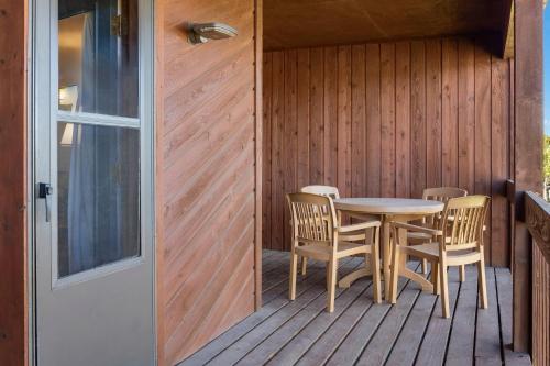 a wooden porch with a table and chairs on a deck at Club Wyndham Pagosa in Pagosa Springs