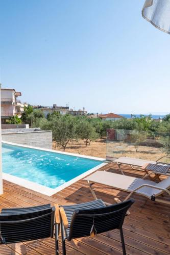 a view of a swimming pool with two chairs on a deck at Petradi Suites in Kalamata