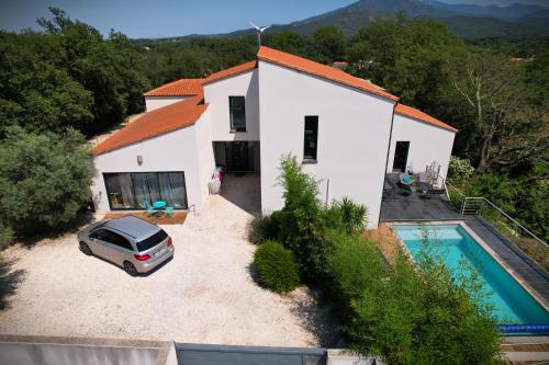 a car parked in front of a house with a pool at Villa contemporaine, jardin méditerranéen et piscine privée in Saint-Jean-Pla-de-Corts