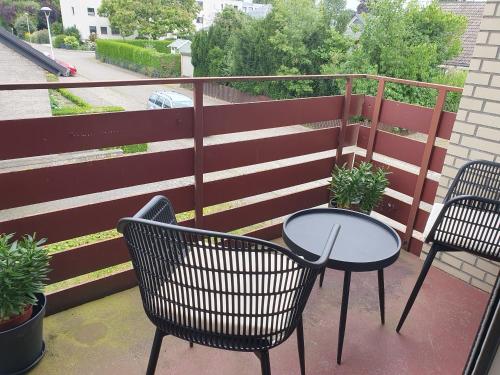 a balcony with two tables and chairs and a fence at Ruhige 1-Zimmer Einliegerwohnung mit Küche und Bad in Großburgwedel in Burgwedel