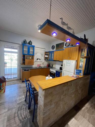 a kitchen with a wooden counter top and blue cabinets at Mama’s Sunshine Garden Villa in Áyios Ilías