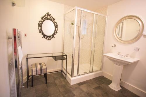a bathroom with a shower, toilet, and sink at The Dolphin Hotel Exmouth in Exmouth
