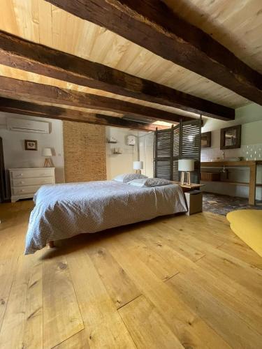a bedroom with a large bed and wooden floors at La Serva in Les Lèches