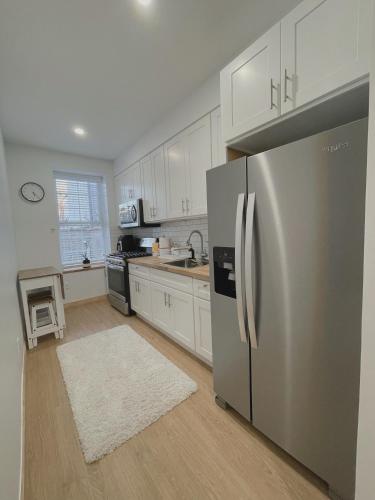 a kitchen with a stainless steel refrigerator and white cabinets at Beautiful Apartment shared with the Host in the Heart of Bushwick in Brooklyn