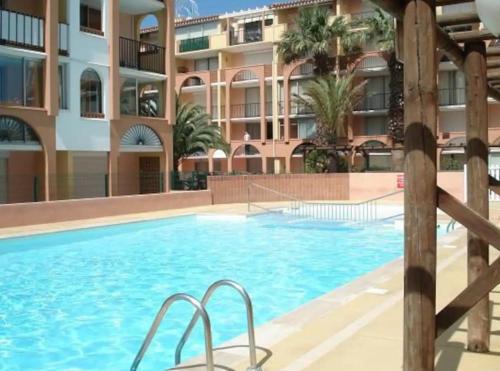 une grande piscine devant un immeuble dans l'établissement Appartement Cap d'Agde, au Cap d'Agde