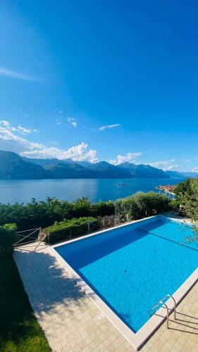 a large swimming pool with a view of the water at WELCOME TRAVELLER Charm Montees Apartment in Brenzone sul Garda