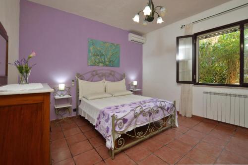 a bedroom with a bed and a purple wall at Villa Torres - Happy Rentals in Scicli