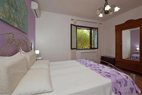 a bedroom with a white bed and a mirror at Villa Torres - Happy Rentals in Scicli