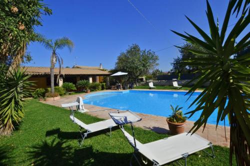 a pool with two lounge chairs and a palm tree at Villa Torres - Happy Rentals in Scicli