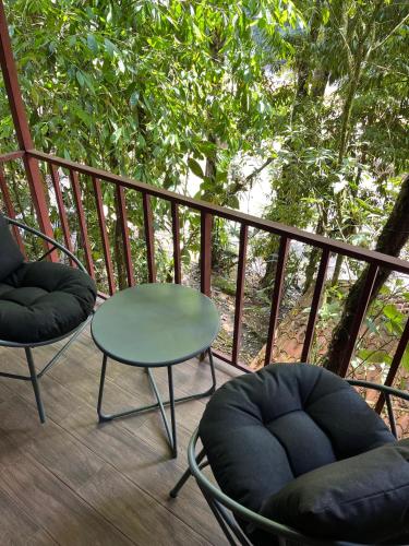 a deck with two chairs and a table and a table at Recreo Verde Hot Springs & Spa in Marsella
