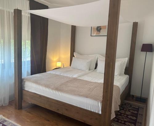 a bedroom with a canopy bed with white sheets and pillows at Soko holiday home Bihac in Bihać