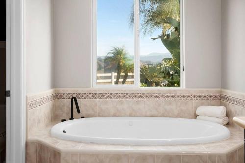 a bath tub in a bathroom with a window at Grenache Estate - Nestled in Temecula Wine Country in Temecula