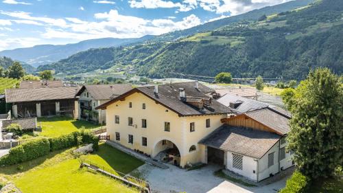 an aerial view of a house with mountains in the background at Untermoarhof Albeins in Bressanone