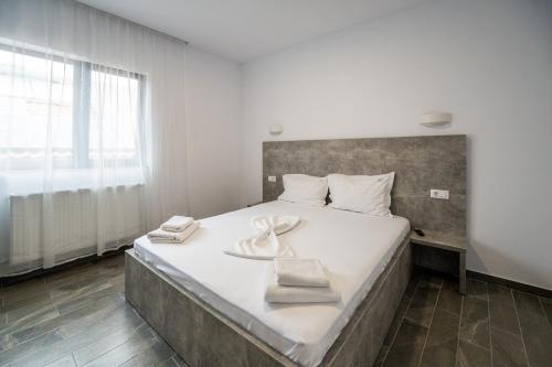 ein Schlafzimmer mit einem großen Bett mit zwei Handtüchern darauf in der Unterkunft Casa Mathias in Eforie Nord