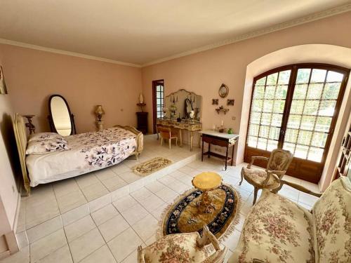 a bedroom with a bed and a living room at Domaine Le Pigeonnier in Loriol-sur-Drôme
