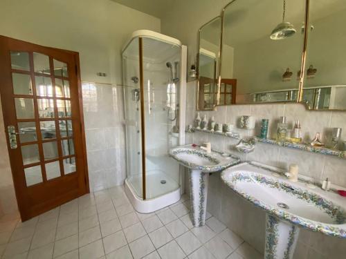 a bathroom with two sinks and a shower and a tub at Domaine Le Pigeonnier in Loriol-sur-Drôme
