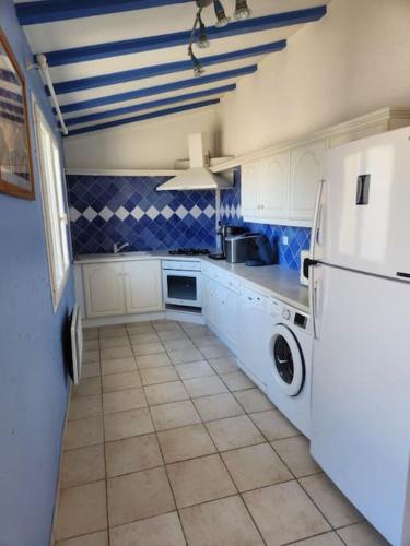 a kitchen with white cabinets and a tile floor at Domaine Le Pigeonnier in Loriol-sur-Drôme