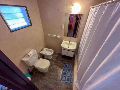 a bathroom with a toilet and a sink and a mirror at Cabañas Del Sol in Valle Grande