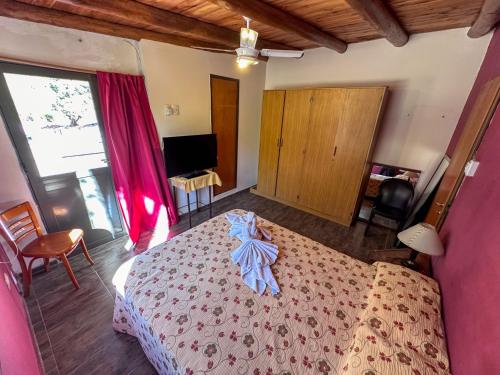 a bedroom with a large bed and a television at Cabañas Del Sol in Valle Grande
