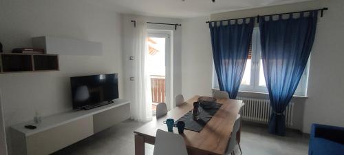 a living room with a couch and a tv at Una Finestra sul Lago in Molveno