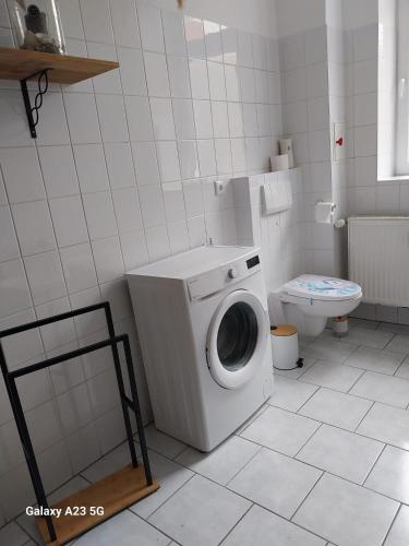 a bathroom with a washing machine and a toilet at FeWo Bismarkstraße 32 - 3Raum in Stendal