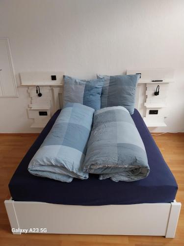 a bed with blue and white pillows on it at FeWo Bismarkstraße 32 - 3Raum in Stendal