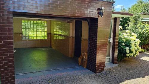 a brick building with an open door with a patio at Puszczykowska willa in Puszczykowo