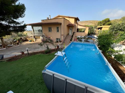a swimming pool in front of a house at Casa vacanze Villa Serena in Pizzolungo