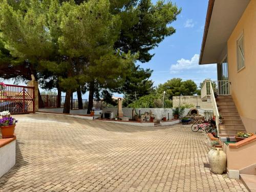 a patio with trees and stairs in a house at Casa vacanze Villa Serena in Pizzolungo