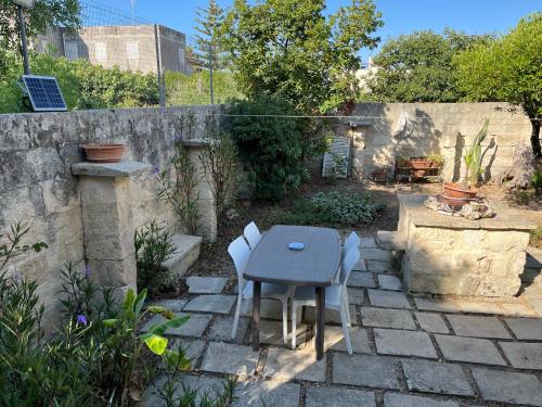 a patio with a table and chairs in a backyard at CASE VACANZA ZOE - LUNA in Serrano