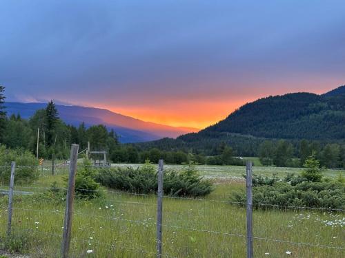 a fence in a field with a sunset in the background at Bluestone Acres Farm in Vavenby