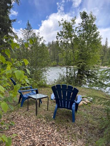 two chairs and a bench in front of a lake at Bluestone Acres Farm in Vavenby