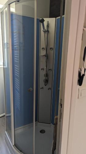 une douche avec une porte vitrée dans une salle de bain dans l'établissement appartement rénové-équipé en centre-ville, au Puy-en-Velay