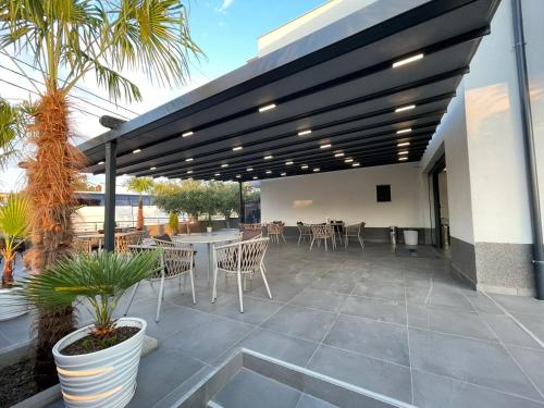 an outdoor patio with chairs and tables and awning at RADINA FAMILY in Kallithea Halkidikis