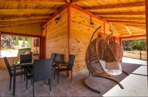 a porch of a cabin with a table and chairs at Planinske kuće Anika Tara minimum 2 noćenja in Mitrovac