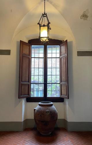 ピストイアにあるPalazzo Bracciolini Nel cuore della cittàの窓付きの部屋に大きな花瓶が置かれています。