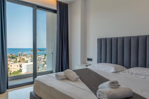 a bedroom with two beds and a large window at Luxury Villas Angela in Ksamil