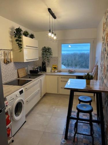 une cuisine avec un lave-linge et une table. dans l'établissement Bel appartement familial proche Versailles, à Vélizy-Villacoublay