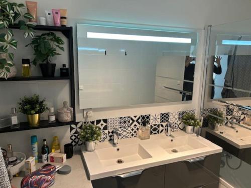 ein Badezimmer mit zwei Waschbecken und einem großen Spiegel in der Unterkunft Bel appartement familial proche Versailles in Vélizy-Villacoublay