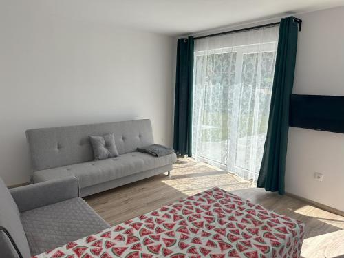 a living room with a couch and a large window at Domki Pasieka Domek C in Przeczyce