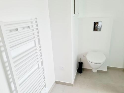 La salle de bains blanche est pourvue de toilettes. dans l'établissement La Belle Emeraude-Appart cosy proche Paris avec parking, à Alfortville