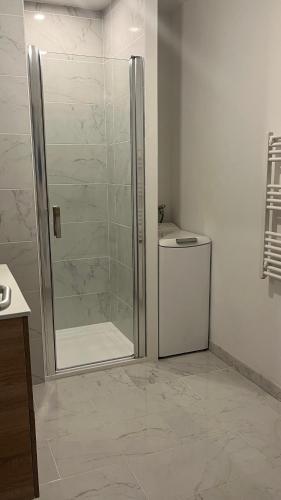 une salle de bain avec une douche avec une porte vitrée dans l'établissement Maison Familiale Les hirondelles, à Magalas